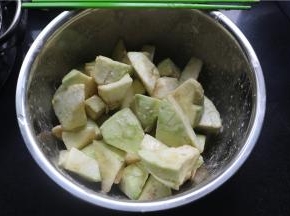 将茄子去皮，滚刀切成方块，在盆里打入一个鸡蛋，3勺淀粉搅拌均匀。
