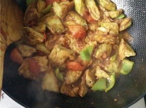 在炸完茄子的油里加入葱姜蒜爆香，之后放入切好的西红柿与青椒，西红柿出汁后放入炸好的茄子