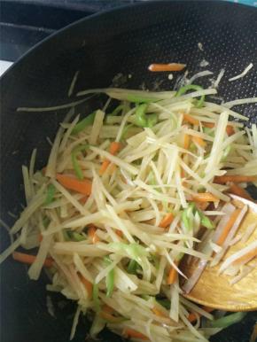 土豆丝沥干水、胡萝卜丝、尖椒丝倒入锅中翻炒，之后加入少量生抽、盐、香醋。