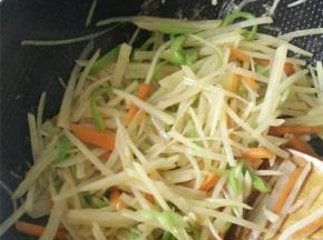 土豆丝沥干水、胡萝卜丝、尖椒丝倒入锅中翻炒，之后加入少量生抽、盐、香醋。