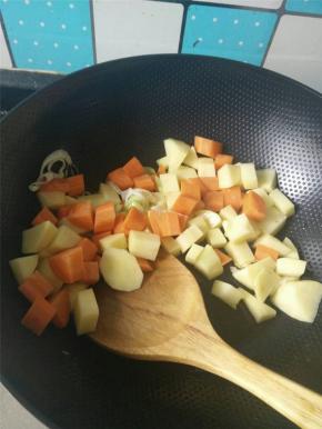 锅烧热，加入适量的食用油，葱炒香之后加入土豆块与胡萝卜块翻炒