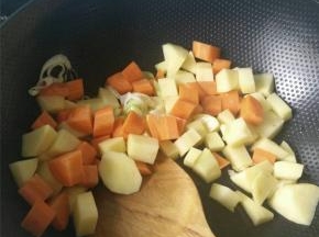 锅烧热，加入适量的食用油，葱炒香之后加入土豆块与胡萝卜块翻炒