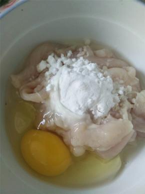 将猪肉切薄片，在其中打入一颗鸡蛋，加少量淀粉搅拌均匀。