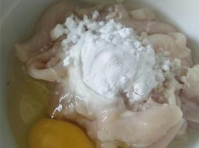 将猪肉切薄片，在其中打入一颗鸡蛋，加少量淀粉搅拌均匀。