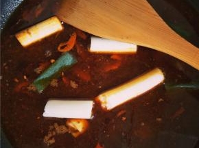 炒出红油后，加水熬制，此时放入葱段