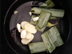 电饭煲内加入水，然后加入葱叶及剩余的姜片和蒜，熬制高汤。等炒锅里的汤煮开熬制5分钟左右倒入电饭煲内继续按煮饭键熬制。