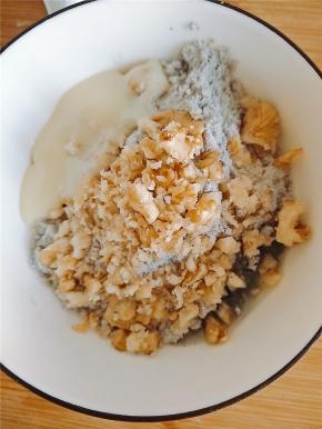 核桃碎倒入芝麻糊里，并且加入炼奶，少许牛奶和植物油，搅拌均匀。