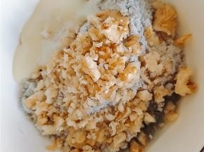 核桃碎倒入芝麻糊里，并且加入炼奶，少许牛奶和植物油，搅拌均匀。