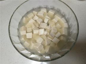 煮好的豆腐捞出放入容器中，将煮豆腐的水倒入容器中没过豆腐即可
