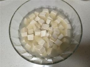 煮好的豆腐捞出放入容器中，将煮豆腐的水倒入容器中没过豆腐即可