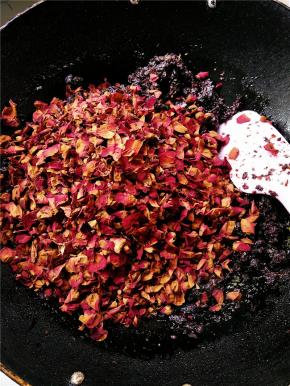 先放入开水烫过的玫瑰花瓣，翻搅1分钟，让其表面充分沾满糖浆，随后加入1/4直接晾干的玫瑰花瓣，一起翻搅。