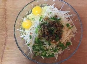 将土豆丝与香葱盛入玻璃器皿中，并加入两颗鸡蛋（依次加入盐、植物油、调味料）搅拌均匀。