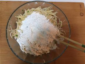 在搅拌均匀的土豆丝中加入面粉（如果觉得干的话可以加入适量水）搅拌均匀