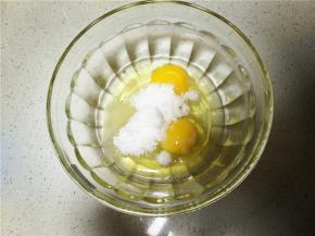 将准备好的鸡蛋打入无水无油的碗中，并加入细砂糖用手动打蛋器搅拌均匀