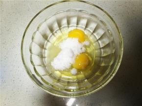 将准备好的鸡蛋打入无水无油的碗中，并加入细砂糖用手动打蛋器搅拌均匀