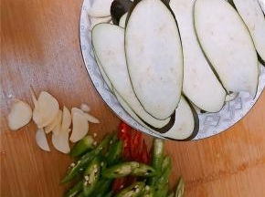 茄子切成椭圆片，蒜切片，青椒切碎。