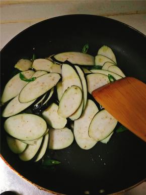 翻炒几下后放入茄片，随后加入花椒粉、鸡精、少许海鲜酱油，待茄子抄软后加入盐调味，若发现粘锅，立即加入少许水，继续翻炒。