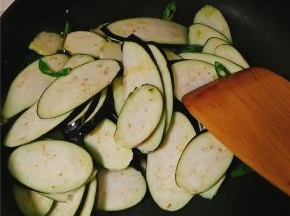 翻炒几下后放入茄片，随后加入花椒粉、鸡精、少许海鲜酱油，待茄子抄软后加入盐调味，若发现粘锅，立即加入少许水，继续翻炒。