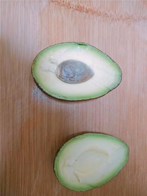牛油果一切为二，有一个很大的果核，果肉为黄绿色，味如牛油，被称为“森林的牛油”。