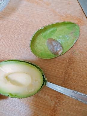 用勺子沿着果皮边缘慢慢掏出果肉。