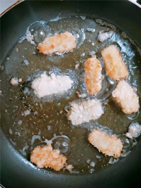 锅内入油，小火烧热，将粘裹好的奶块放入锅中，小心翻动，以防粘连。