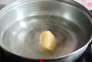 取一个洁净无油的锅，水开后放冰糖，待其全部融化后放入剥好的橘子，