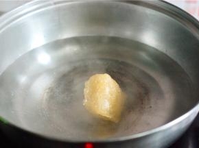 取一个洁净无油的锅，水开后放冰糖，待其全部融化后放入剥好的橘子，