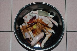 把浸好的鸭主料放进电饭煲内胆里，放老抽、料酒、姜块（拍碎）、一包卤料（王守义）、干辣椒、盐、鸡精适量，拌匀，按鸡鸭模式，大概30分钟样子