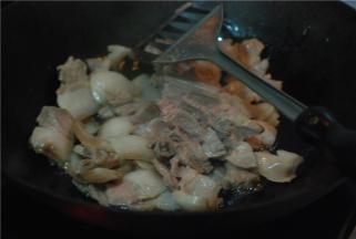 炒锅放少量油，把切好的猪肉煸炒，肉片炒至透明，微微卷起后放花椒、姜蒜翻炒