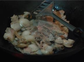 炒锅放少量油，把切好的猪肉煸炒，肉片炒至透明，微微卷起后放花椒、姜蒜翻炒