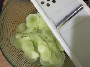 用擦片工具把去了皮的莴笋擦出薄薄的一片