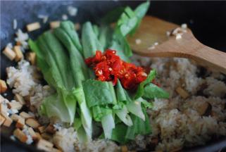 生抽上色均匀后，把莴笋叶和剁椒放进去翻炒，加一勺花椒油