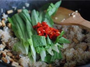 生抽上色均匀后，把莴笋叶和剁椒放进去翻炒，加一勺花椒油