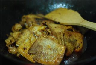 加煎好的嫩豆腐翻炒，放一小碗水，稍微焖一下让豆腐吸收汤汁，以便入味。最后加适量盐、鸡精调味即可出锅。