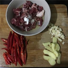 准备食材，牛腩切小块，加适量料酒、淀粉、蛋清抓匀放置10分钟，红辣椒滚刀切块，姜切片、蒜切末