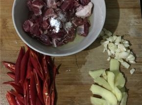 准备食材，牛腩切小块，加适量料酒、淀粉、蛋清抓匀放置10分钟，红辣椒滚刀切块，姜切片、蒜切末