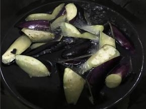 热锅倒多量油炸茄子，表面变色即可沥油装盘备用