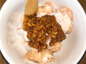 和好的调料倒进鸡翅根碗中，抓匀