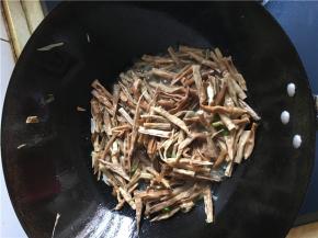 炒锅倒少量油，烧热后葱花，蒜片和切好的笋干一起倒入，翻炒1分钟后加入料酒