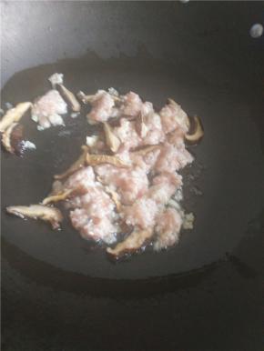 锅中热油加入香菇炒出香味。倒入腌制过的肉末一起炒。