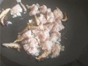 锅中热油加入香菇炒出香味。倒入腌制过的肉末一起炒。