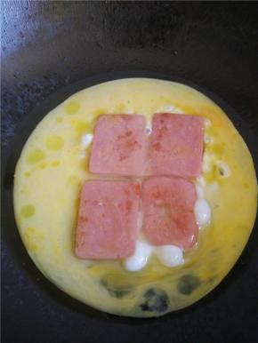 把火腿煎到两面微黄，即可倒入鸡蛋。