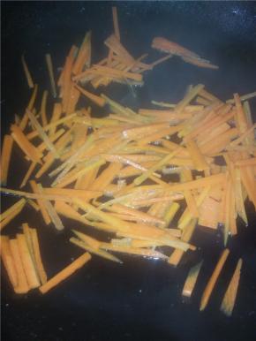 锅里加入橄榄油，放入胡萝卜炒，片刻后加入金针菇。