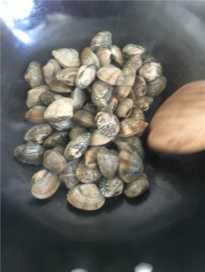 把表面洗干净的花蛤直接倒入热锅中干炒