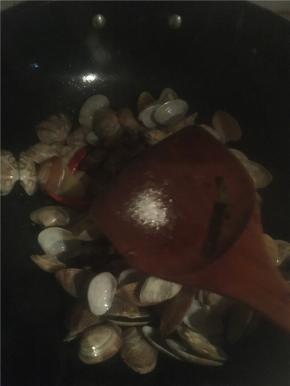 倒入花蛤翻炒，加入料酒、酱油、耗油和白糖，少许盐翻炒