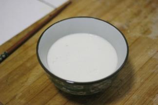 加热后的牛奶倒入另一个锅内，在倒回原来的锅里，反复几回让牛奶的温度稍微降低一些，然后牛奶快速的倒入姜汁中