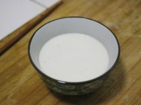 加热后的牛奶倒入另一个锅内，在倒回原来的锅里，反复几回让牛奶的温度稍微降低一些，然后牛奶快速的倒入姜汁中