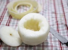 在雪梨的顶端三分之一处切开，当做盖子，用勺子将梨核挖出来