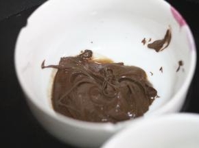 黑巧克力同样融化，在奶牛的一侧耳朵上沾满黑巧，在用牙签点上眼睛和嘴