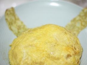 炒好的饭倒入1张蛋皮上，蛋皮盖住米饭包成圆形作为皮卡丘的脸